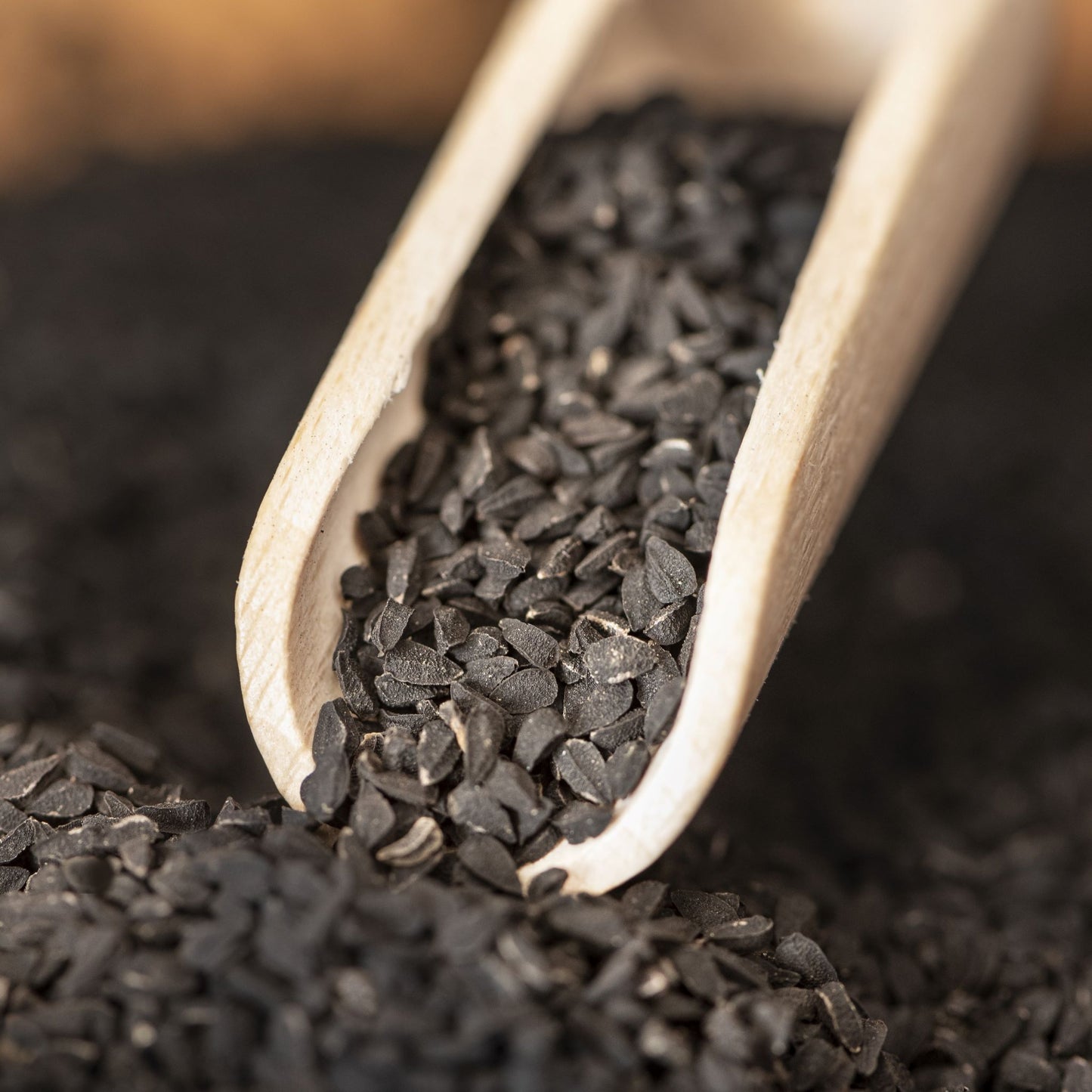 Close up of Black Cumin Seeds and wooden scoop
